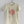 Load image into Gallery viewer, A simple and stylish graphic tee that features a fish and Japanese characters. A cute Japanese shirt that has a unique and stylish graphic design. A navy design with a pink accent on a cream t-shirt.