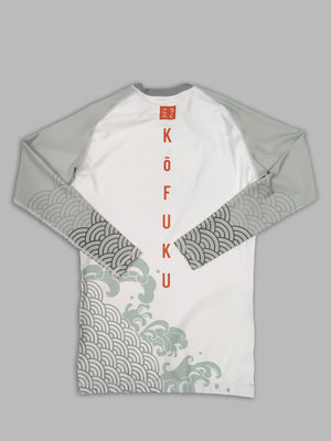 A cool bjj rash guard that features Asian aesthetic graphics. The white jiu jitsu rash guard has gray sleeves and gray graphic elements and a red logo of Kofuku down the center. This is a rash guard for both men's and women's bjj.